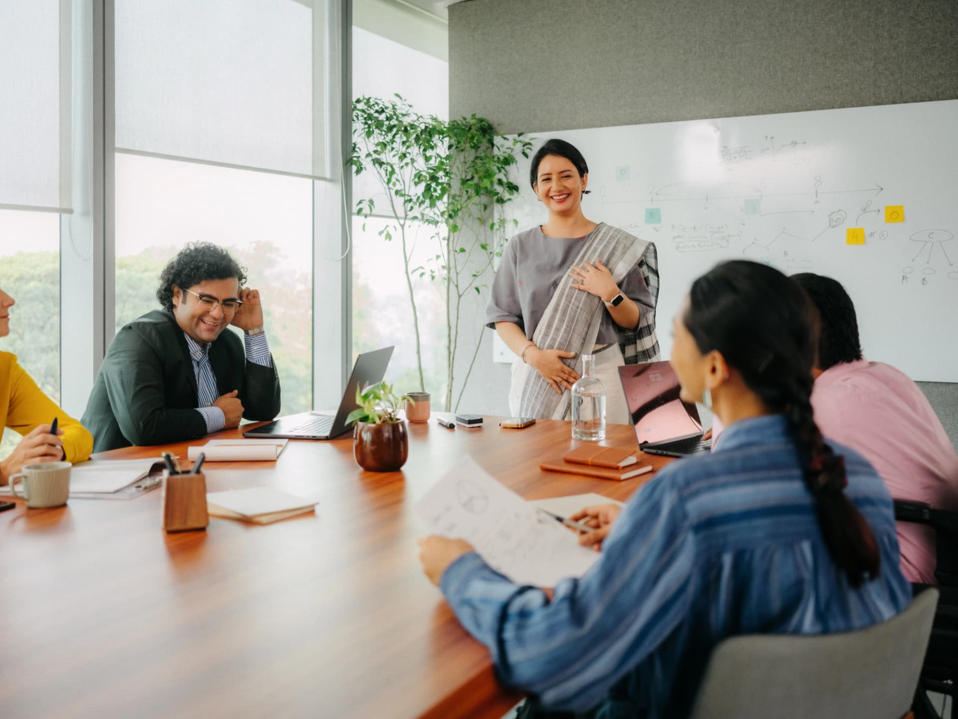 Professional pausing at a window with coffee, reflecting careers and culture at Godrej Wealth